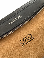 Black leather bag interior close-up with Loewe logo stamp near zip pocket