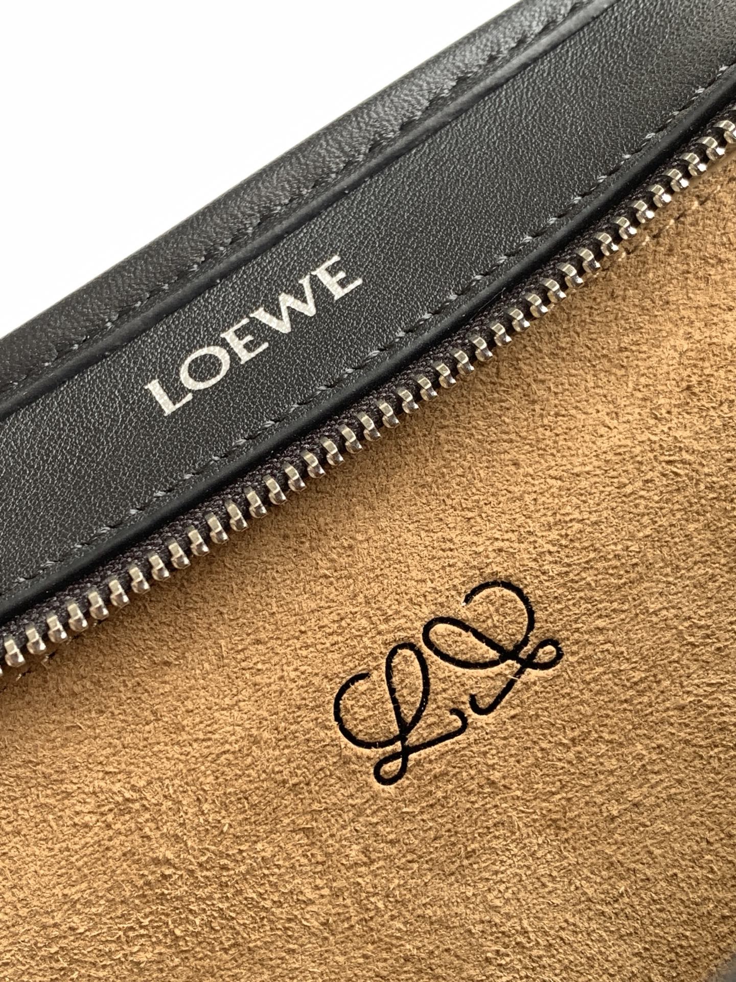 Black leather bag interior close-up with Loewe logo stamp near zip pocket