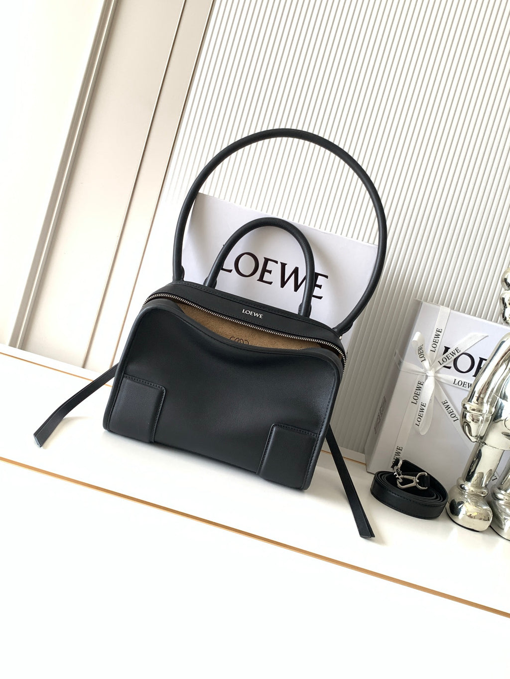 Black Loewe-branded top-handle bag with dual handles and gold-tone zipper