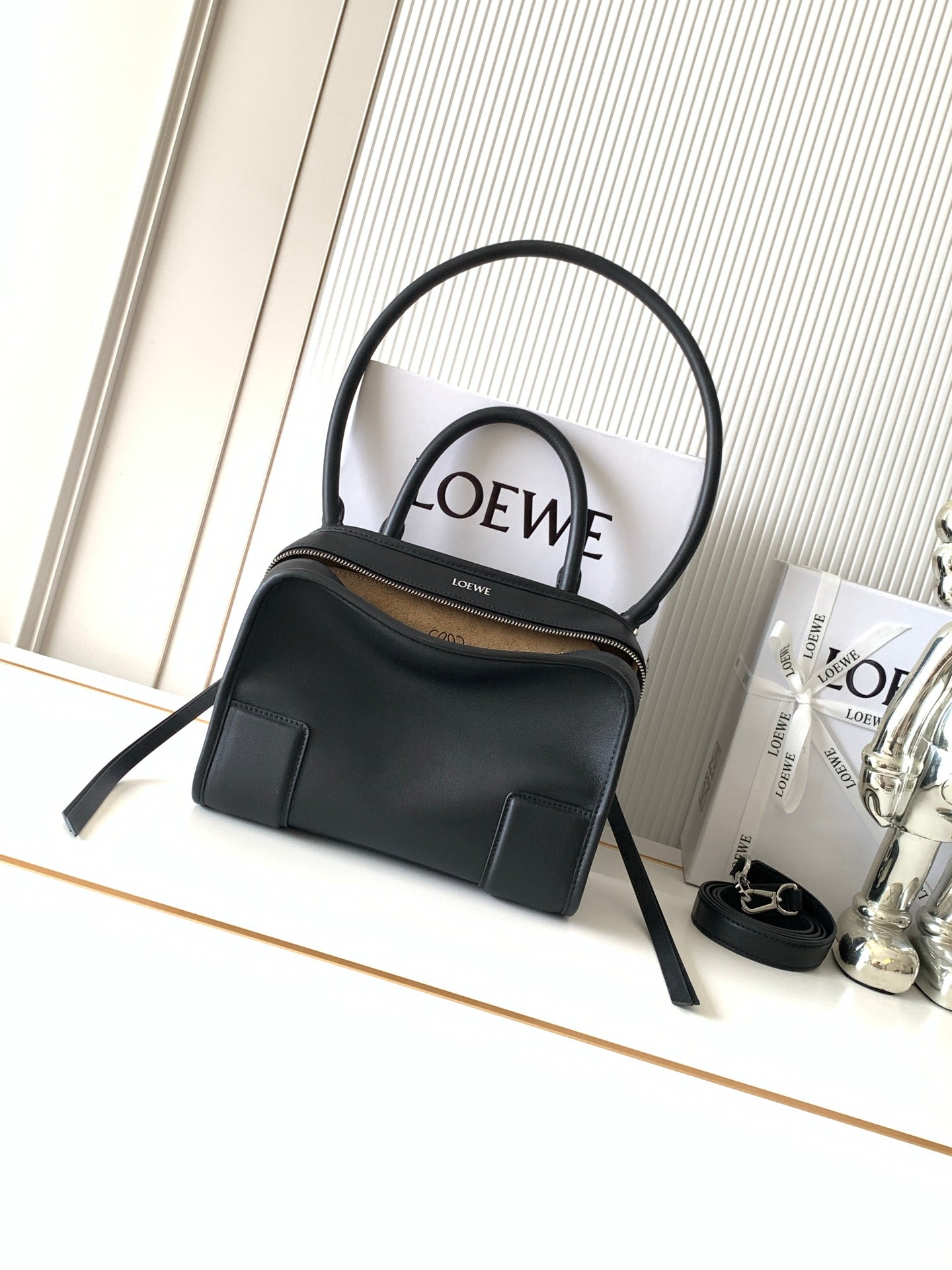 Black Loewe-branded top-handle bag with dual handles and gold-tone zipper