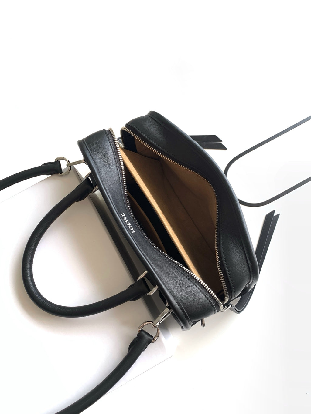 Black leather bag interior view with zipper closure and adjustable crossbody strap