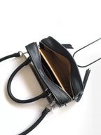Black leather bag interior view with zipper closure and adjustable crossbody strap