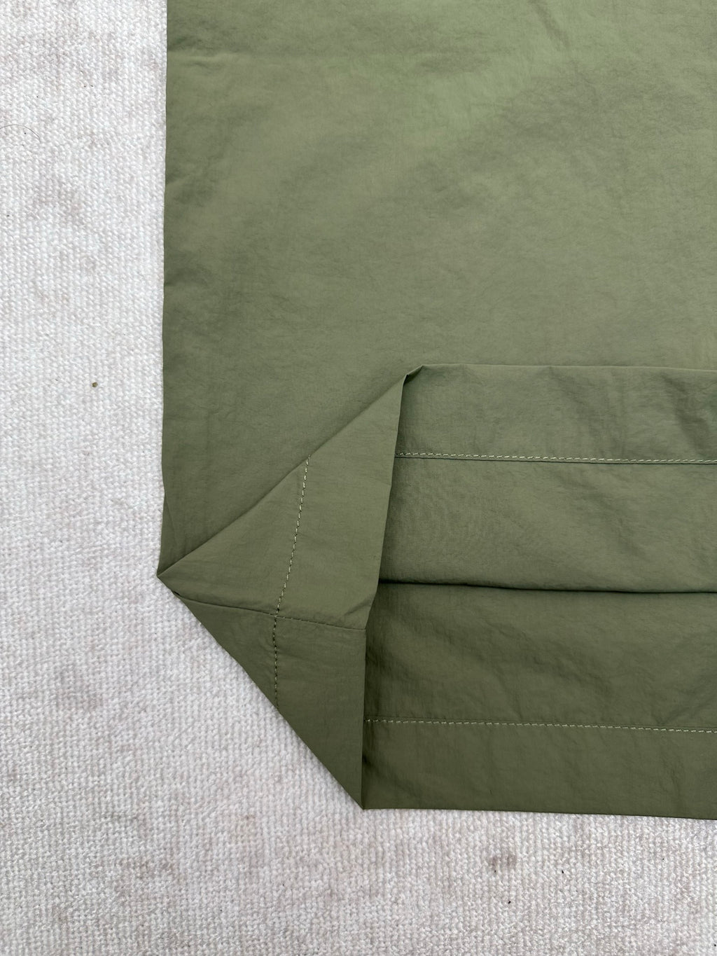 Olive green Louis Vuitton pants fabric close-up at folded hem and side seam