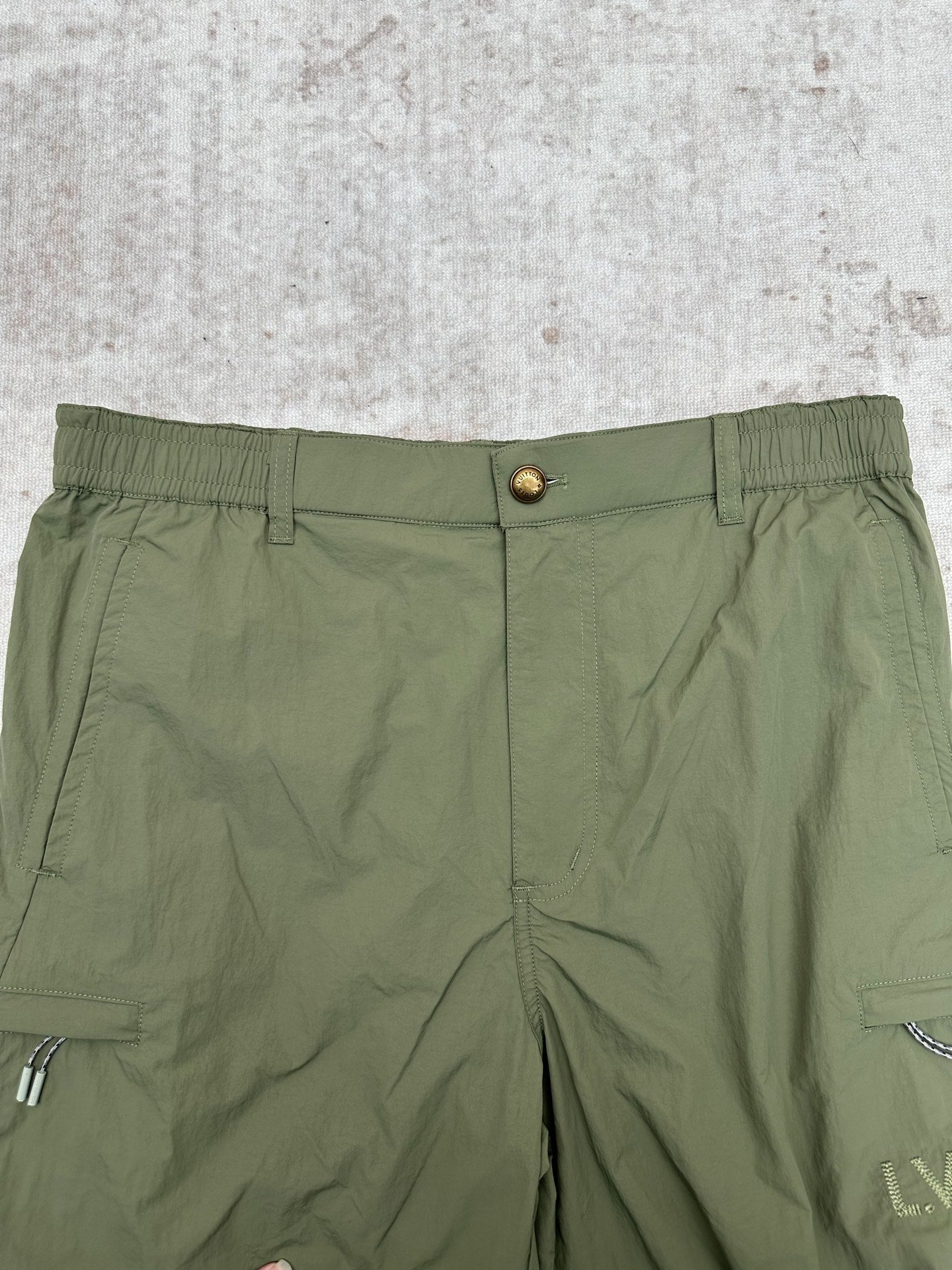 Olive green Louis Vuitton pants waistband with button closure and front pleated seams