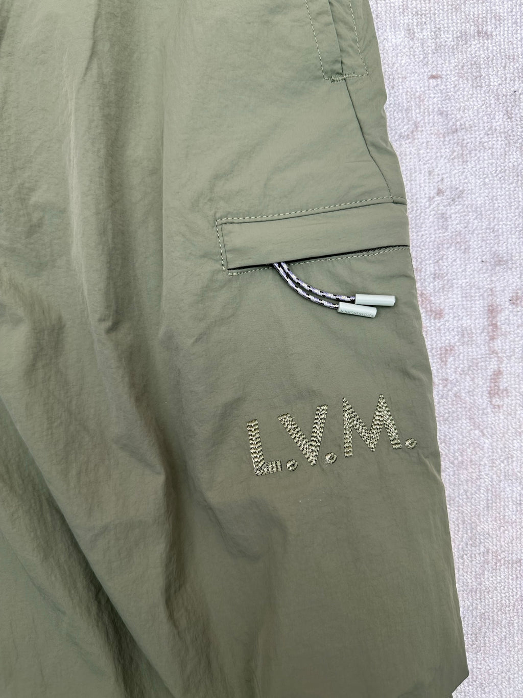 Olive green Louis Vuitton pants with side welt pocket and embroidered logo detail