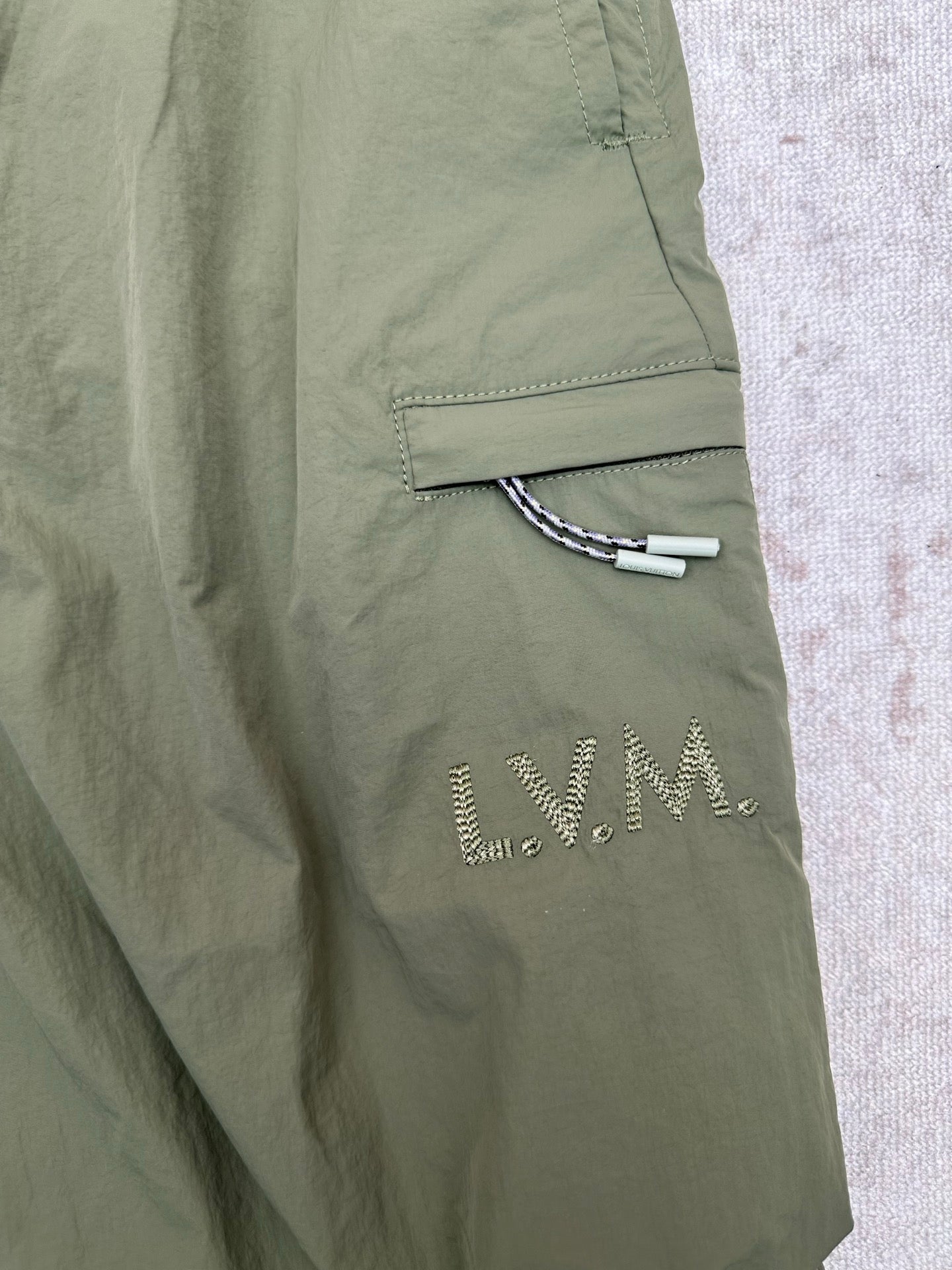 Olive green Louis Vuitton pants with side welt pocket and embroidered logo detail