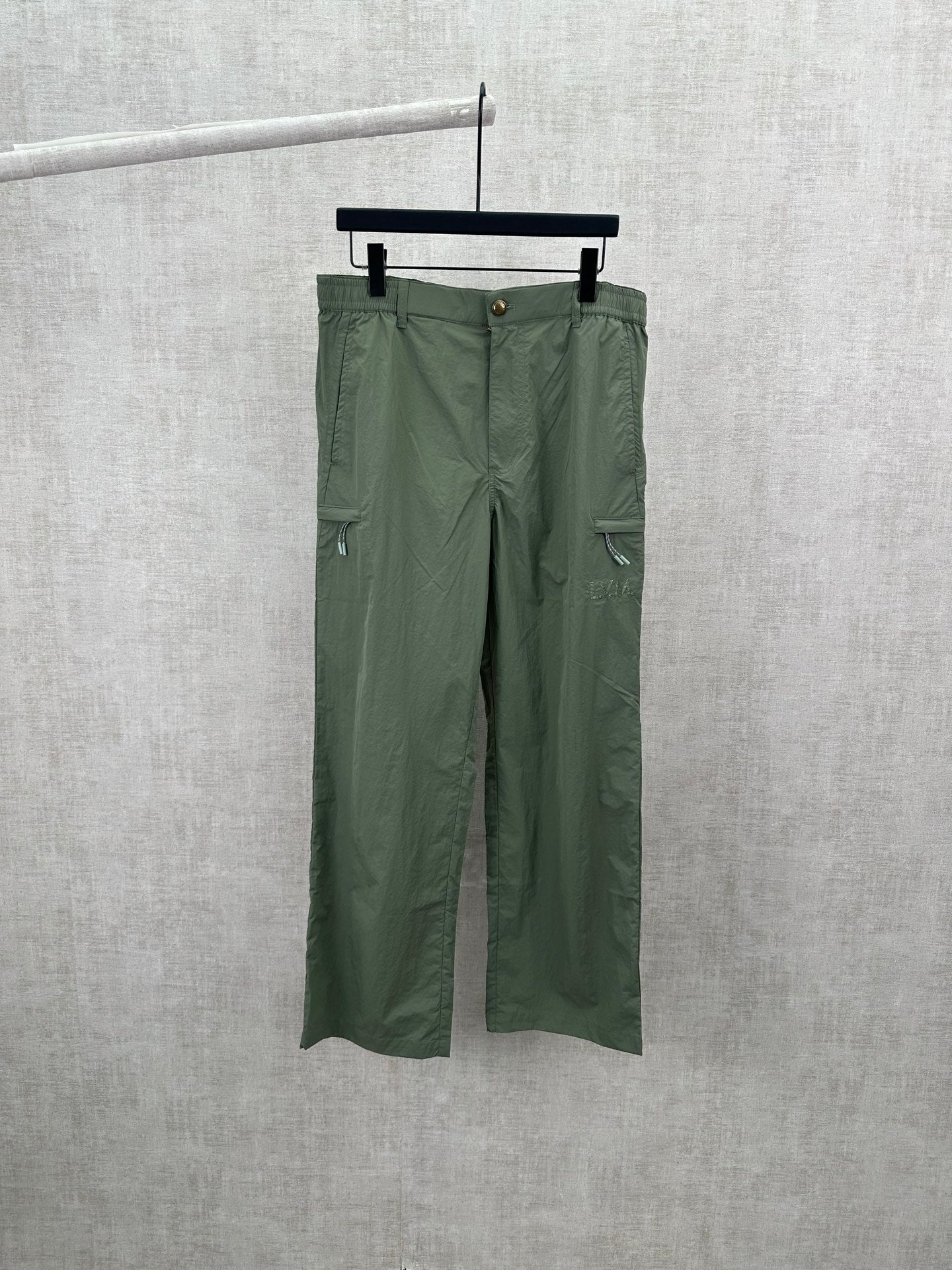 Olive green Louis Vuitton pants, front view with belt loops and button closure