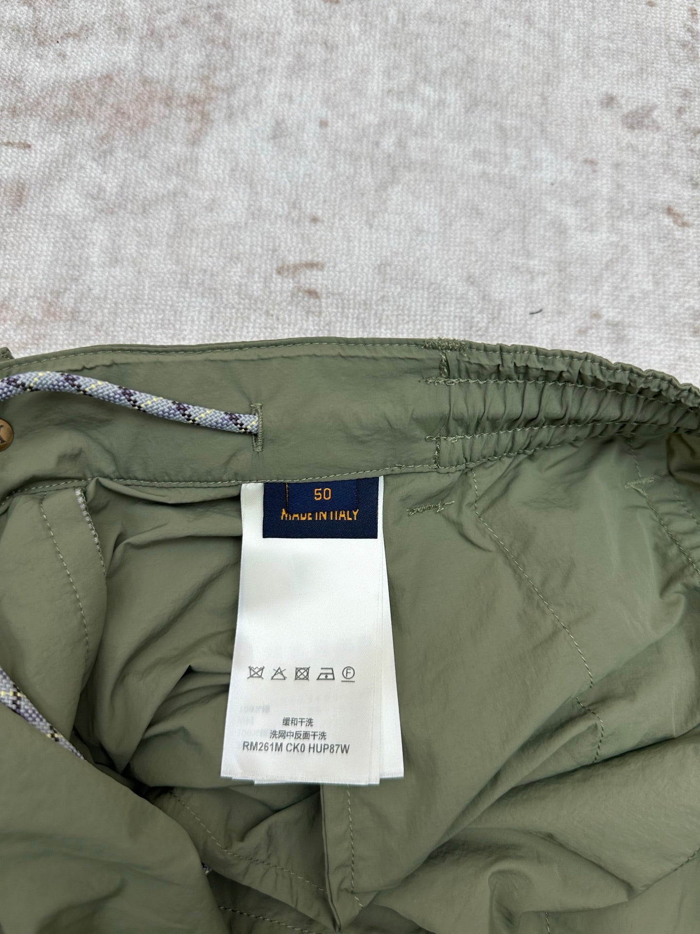 Olive green Louis Vuitton pants inside view with fabric label and drawstring cord