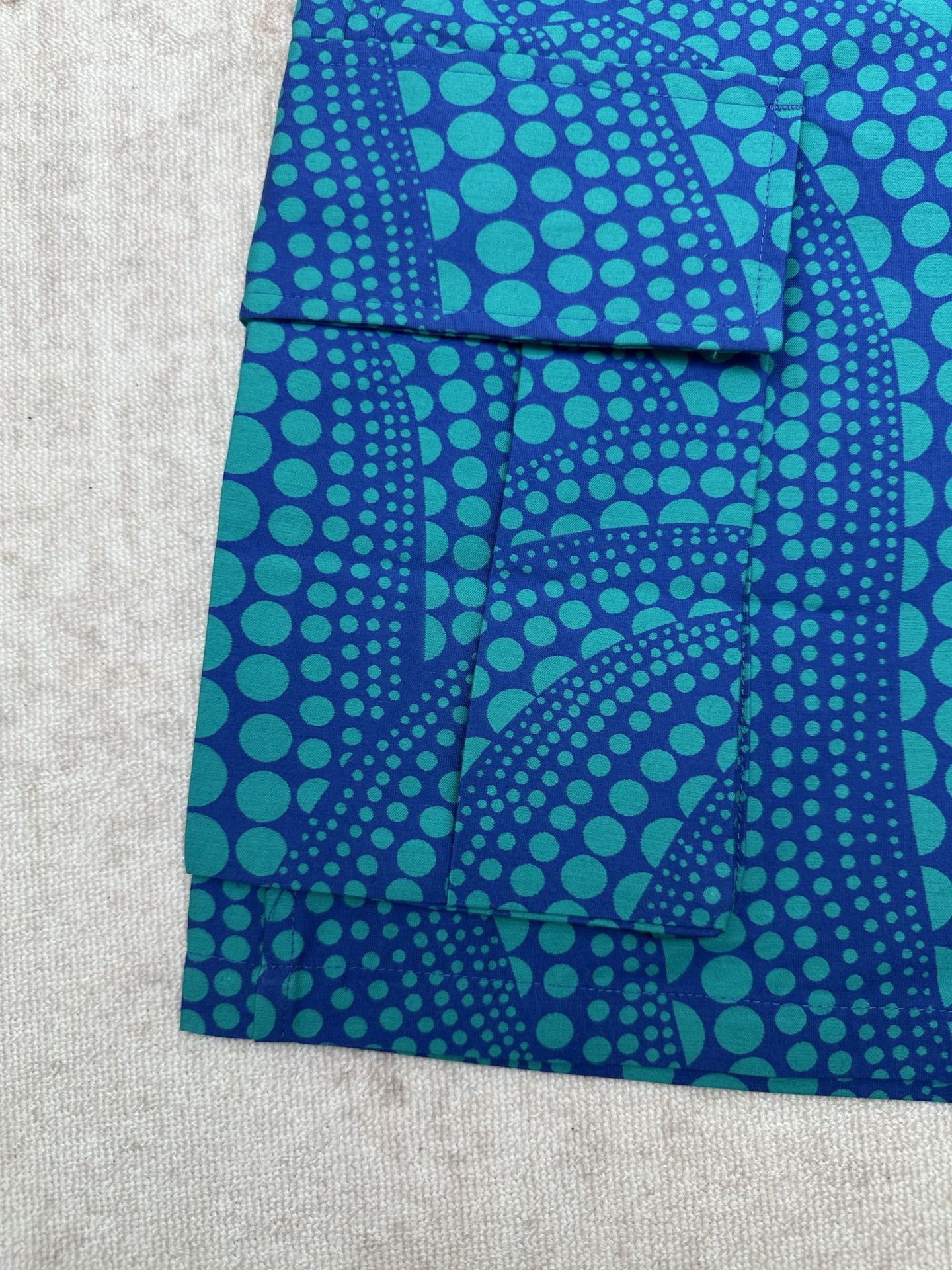 Blue patterned shorts with teal circular motif and patch-style front pockets