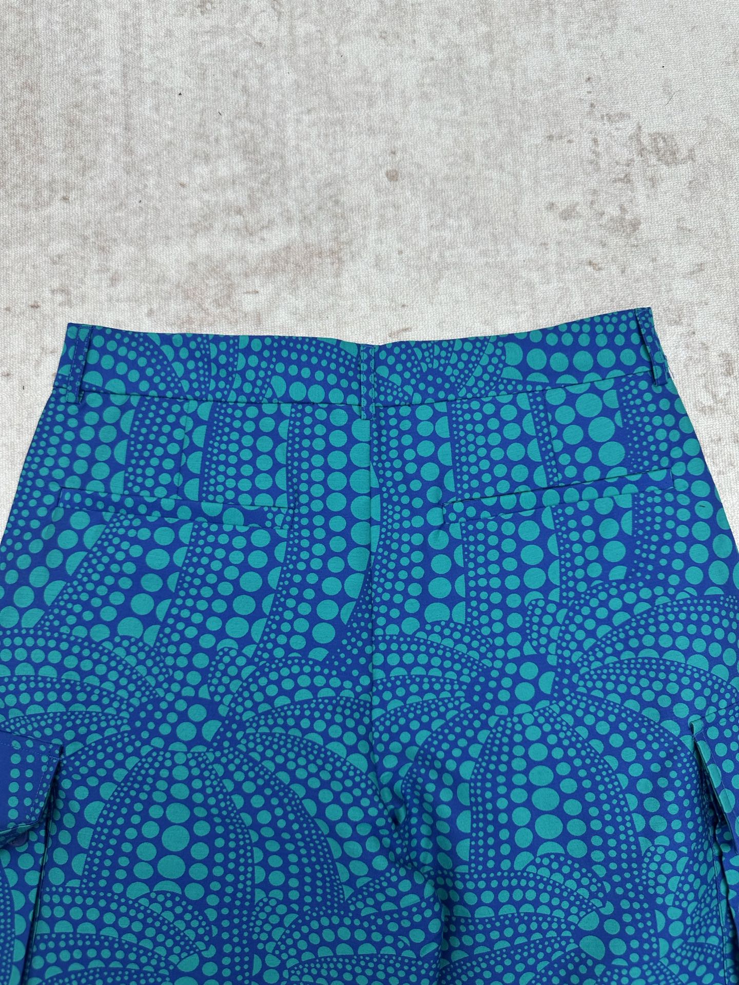 Blue shorts with teal circular pattern and pleated front panel