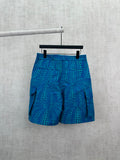 Blue patterned shorts with teal circular motif, elastic waistband and side pockets