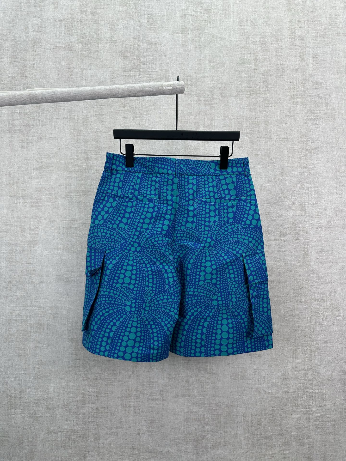 Blue patterned shorts with teal circular motif, elastic waistband and side pockets