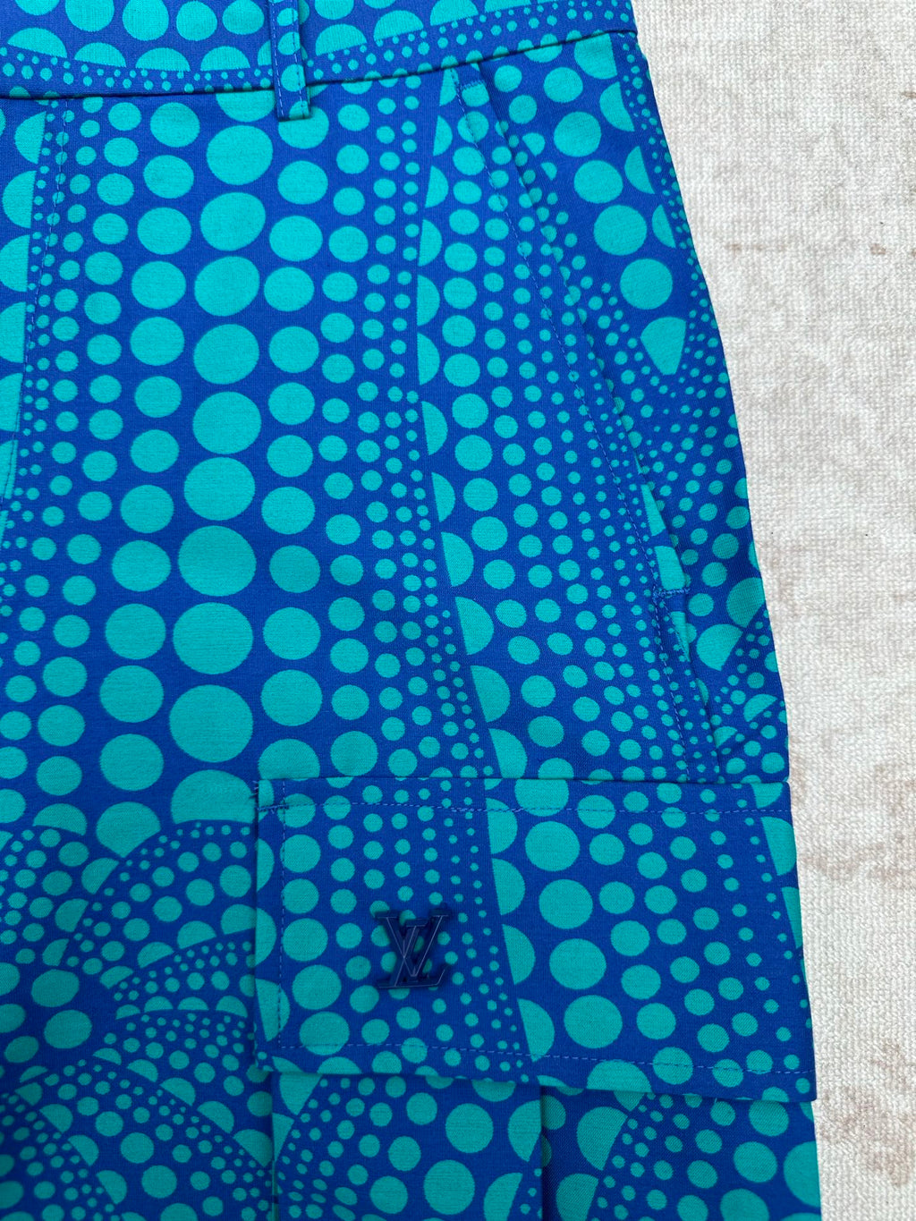 Blue patterned shorts with teal circular print and front crease detail