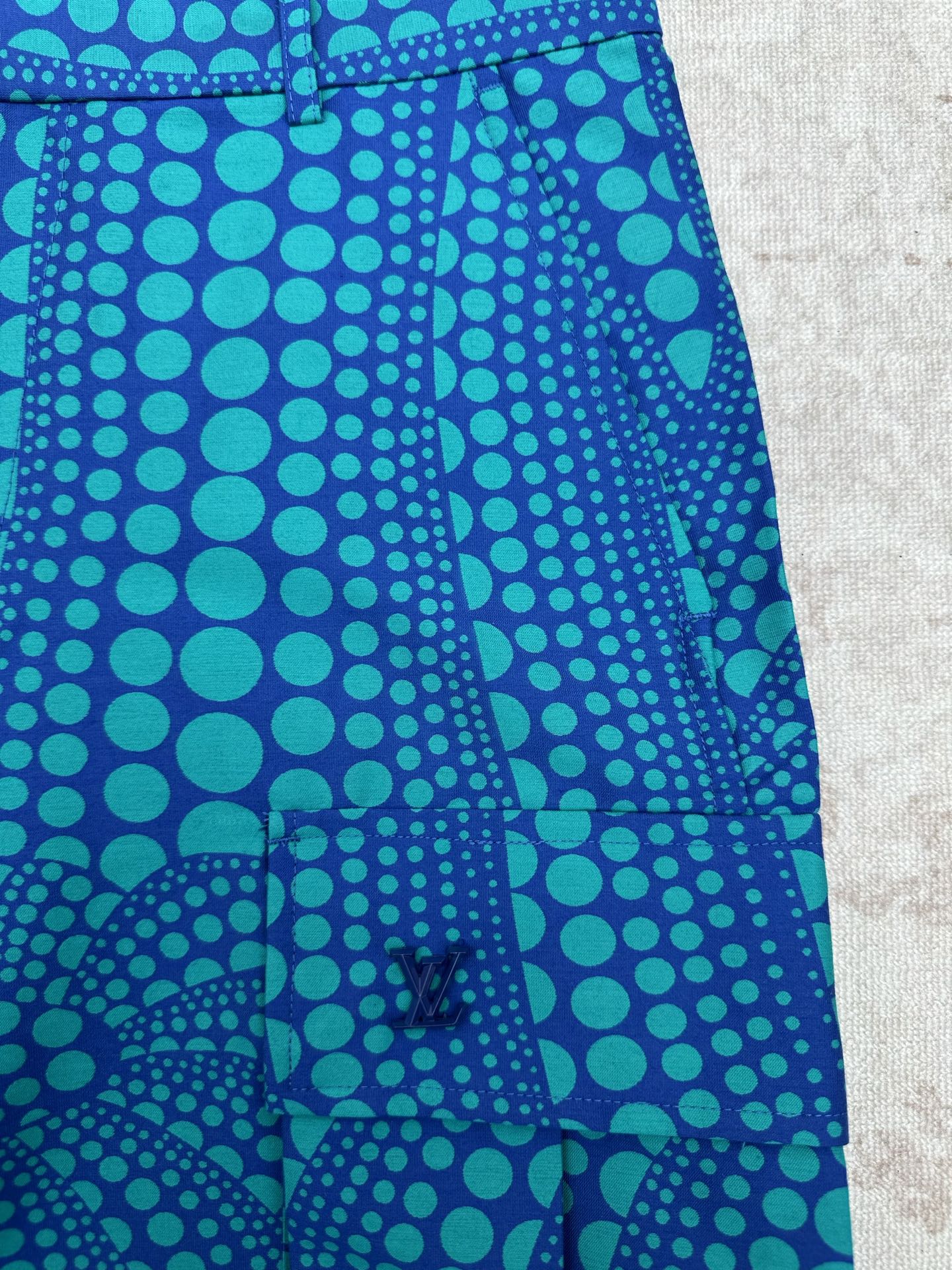 Blue patterned shorts with teal circular print and front crease detail