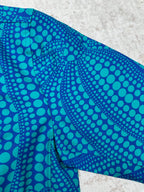 Blue long-sleeve button-up shirt with teal dot pattern on folded side