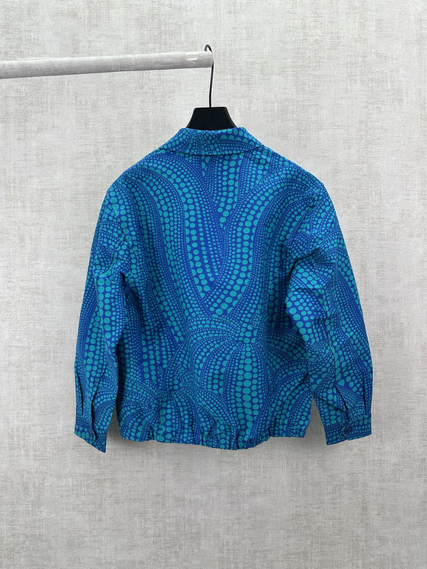 Blue long-sleeve button-up shirt with teal dot pattern, back view
