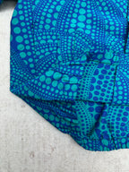 Blue long-sleeve button-up shirt with teal dot pattern, cuff and hem
