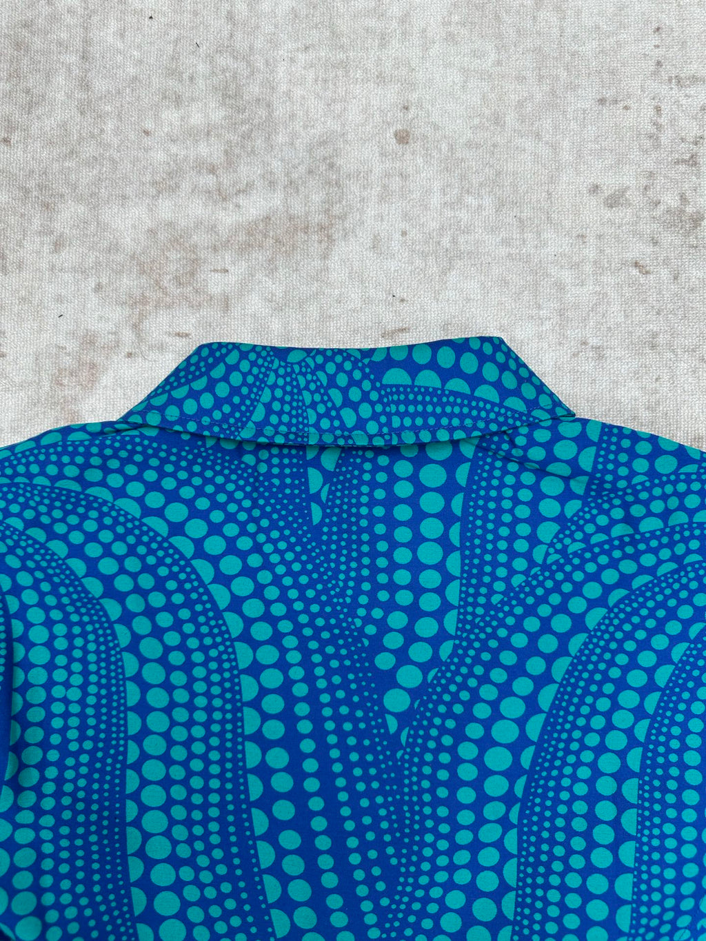 Blue long-sleeve button-up shirt collar with teal dot pattern