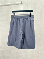 Blue shorts with elastic waistband and dark side stripe, front view.