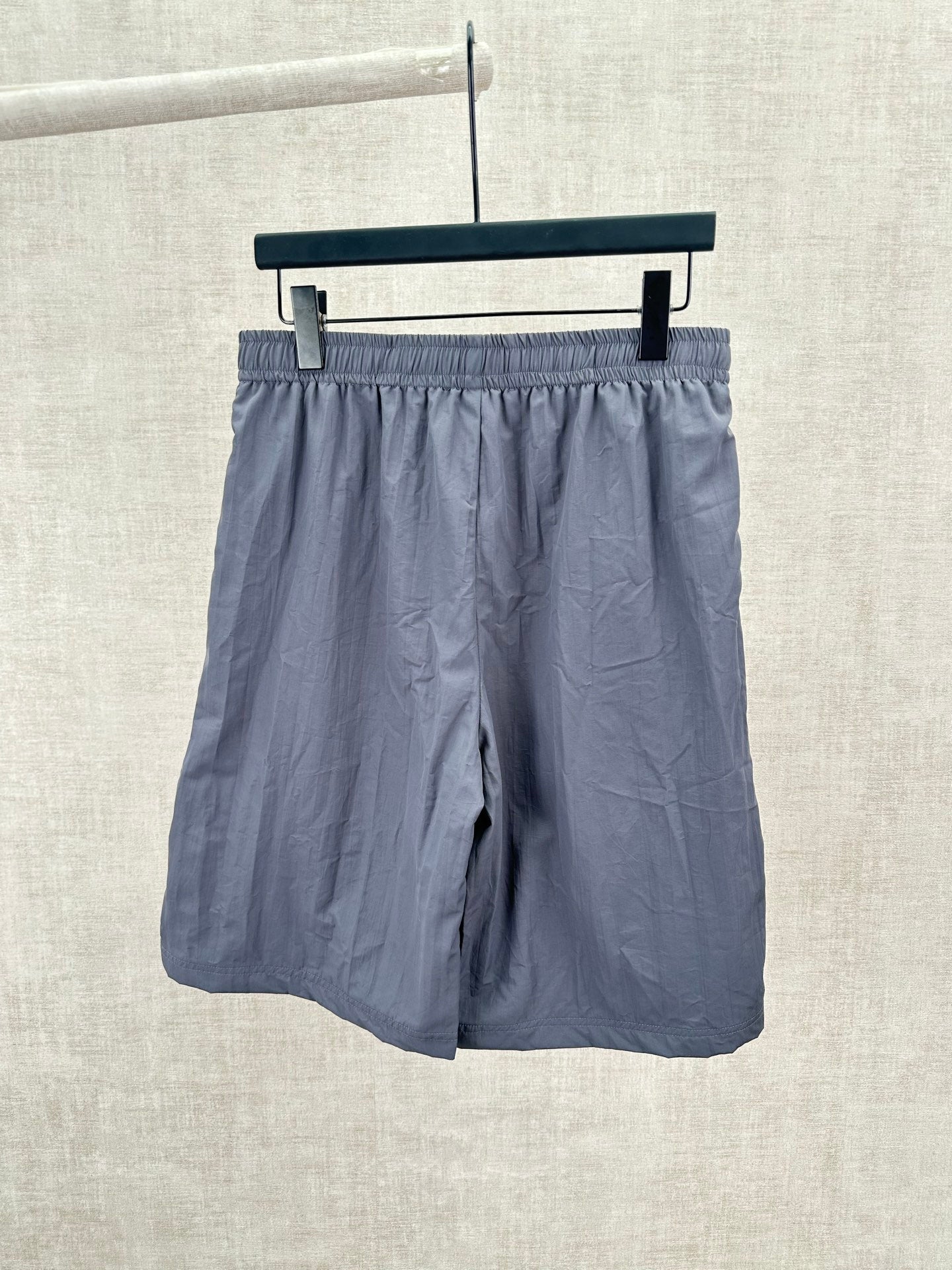 Blue shorts with elastic waistband and dark side stripe, front view.