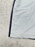 White shorts hem with dark side stripe, close-up of the lower leg.