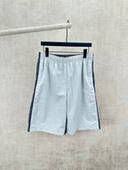 Light blue shorts with elastic waistband and dark side stripe, front view.