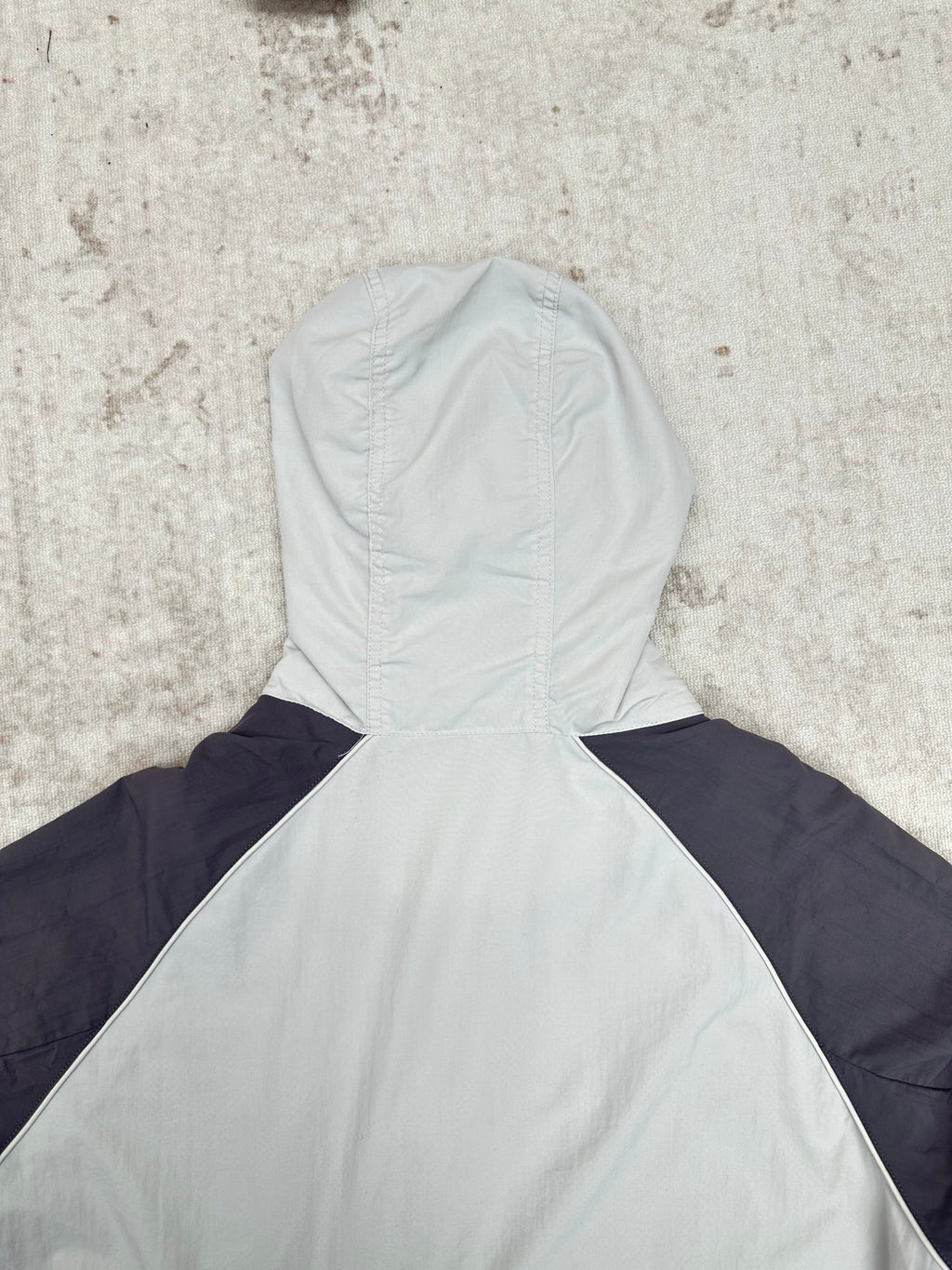 Light blue and navy hooded jacket with high neck, seam detail