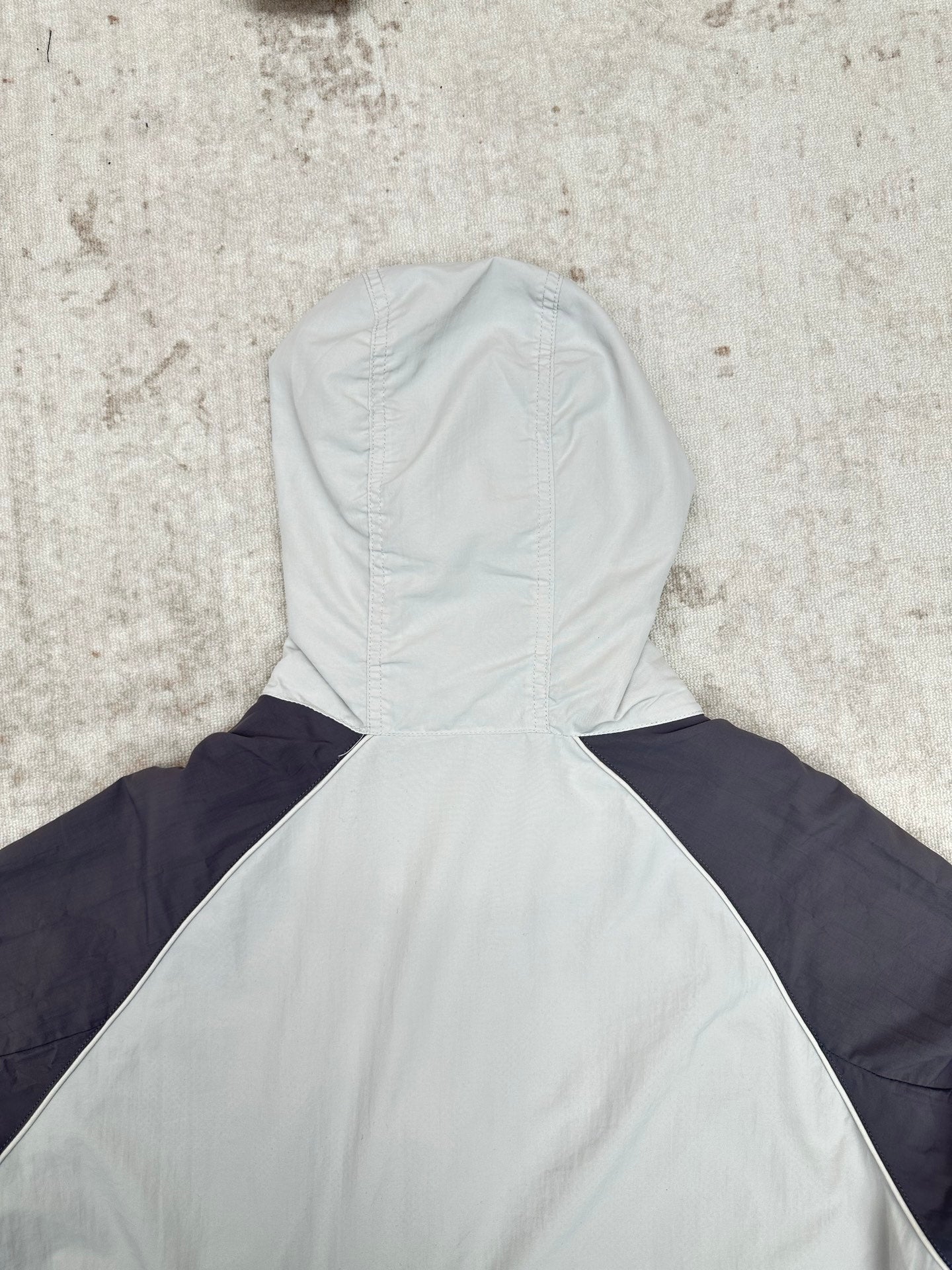 Light blue and navy hooded jacket with high neck, seam detail