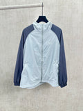 Light blue zip-up hooded jacket with navy sleeves, front zipper closure