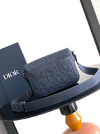Navy crossbody bag with embossed logo flap and wide adjustable shoulder strap