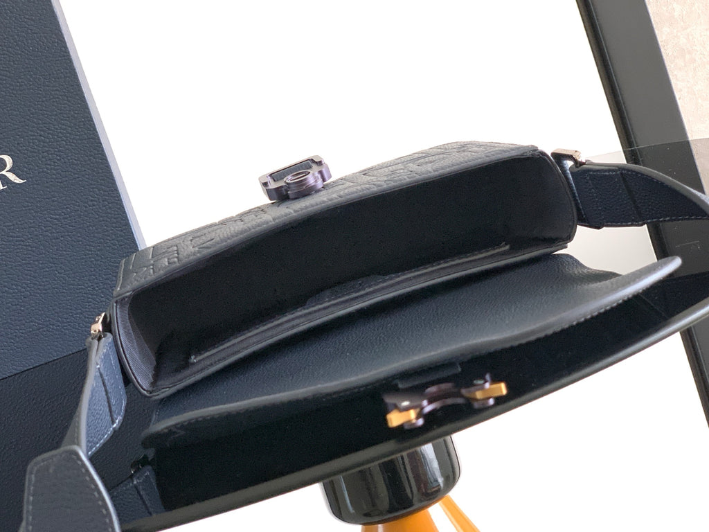 Navy crossbody bag open view with dark interior and front clasp detail