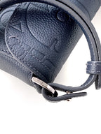 Navy blue Dior bag close-up of leather strap with metal ring and hardware