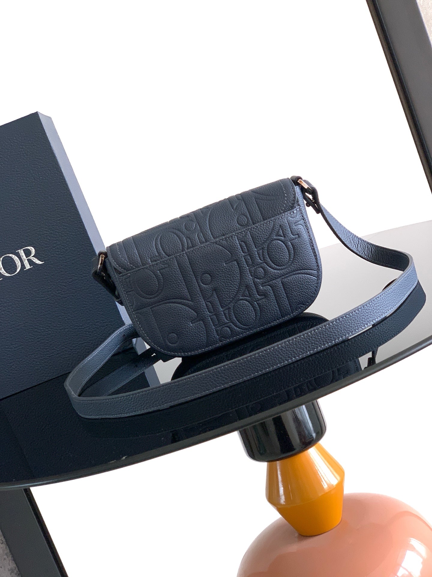 Navy blue Dior crossbody bag with embossed logo and shoulder strap