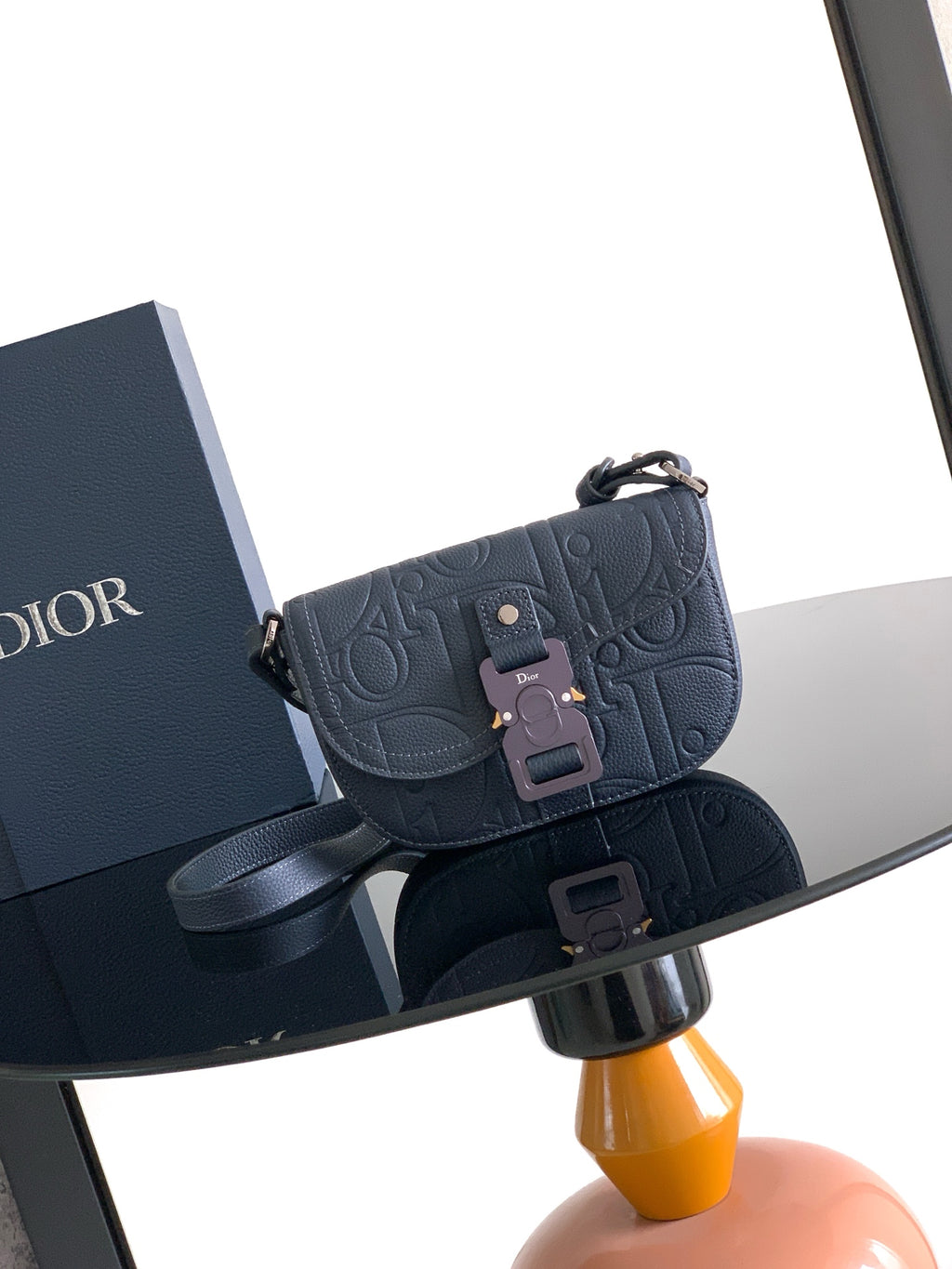 Navy blue Dior crossbody bag with embossed logo and front flap closure