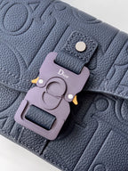 Navy blue Dior bag close-up of logo charm and metal front clasp