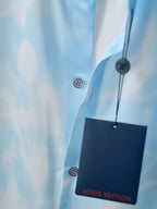 Light blue button-up shirt with visible buttons and hanging Louis Vuitton tag