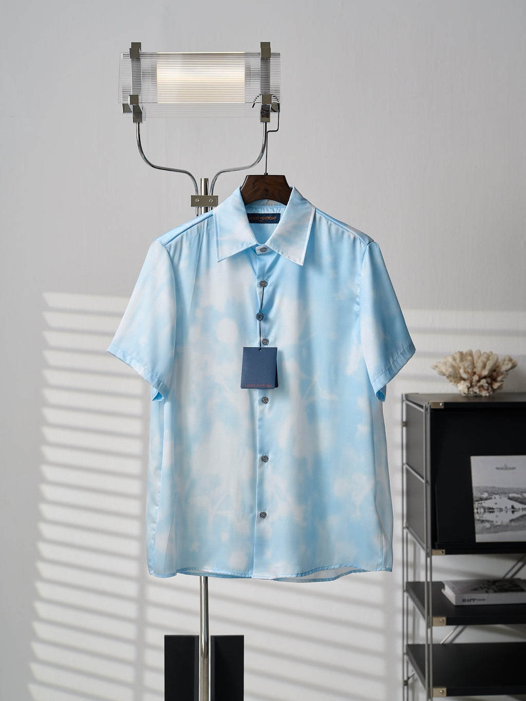 Sky blue short-sleeve button-up shirt on hanger, allover light pattern, button placket