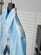 Light blue short-sleeve button-up shirt, side view showing shoulder and sleeve