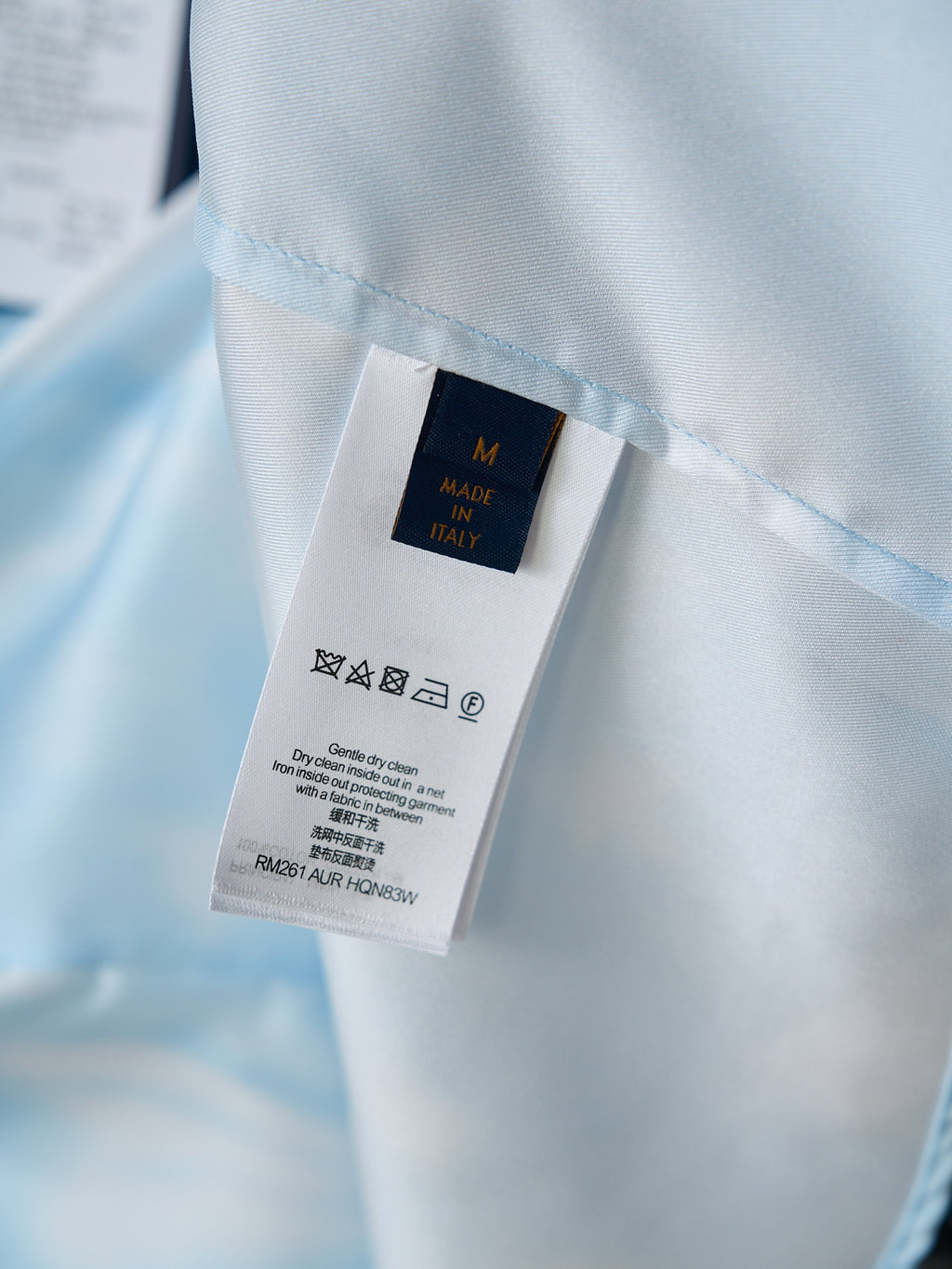 Light blue shirt care label tag showing size M and Made in Italy