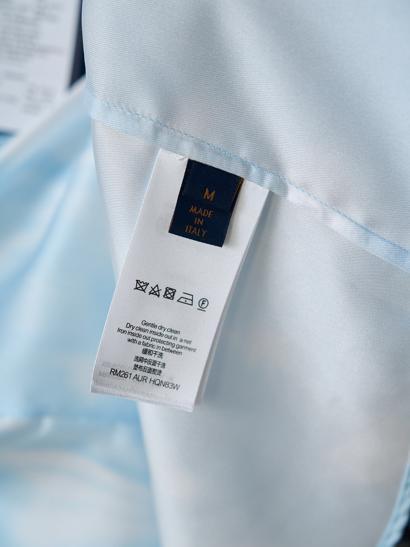 Light blue shirt care label tag showing size M and Made in Italy