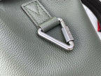 Louis Vuitton leather backpack close-up of metal carabiner hardware on sage green leather.