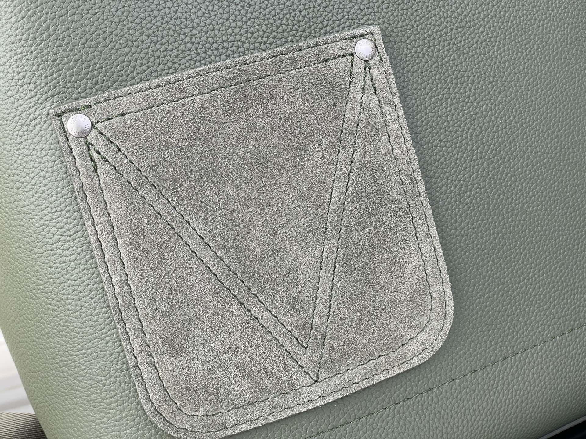 Louis Vuitton leather backpack front pocket panel with stitched trim, sage green.