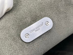 Louis Vuitton metal tab with screws on gray bag strap