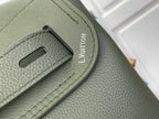 Louis Vuitton leather backpack strap adjuster close-up with embossed LV mark, sage green.