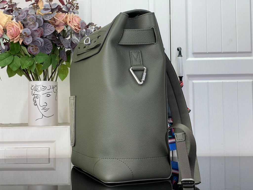 Louis Vuitton leather backpack side view with top handle and metal loop, sage green.