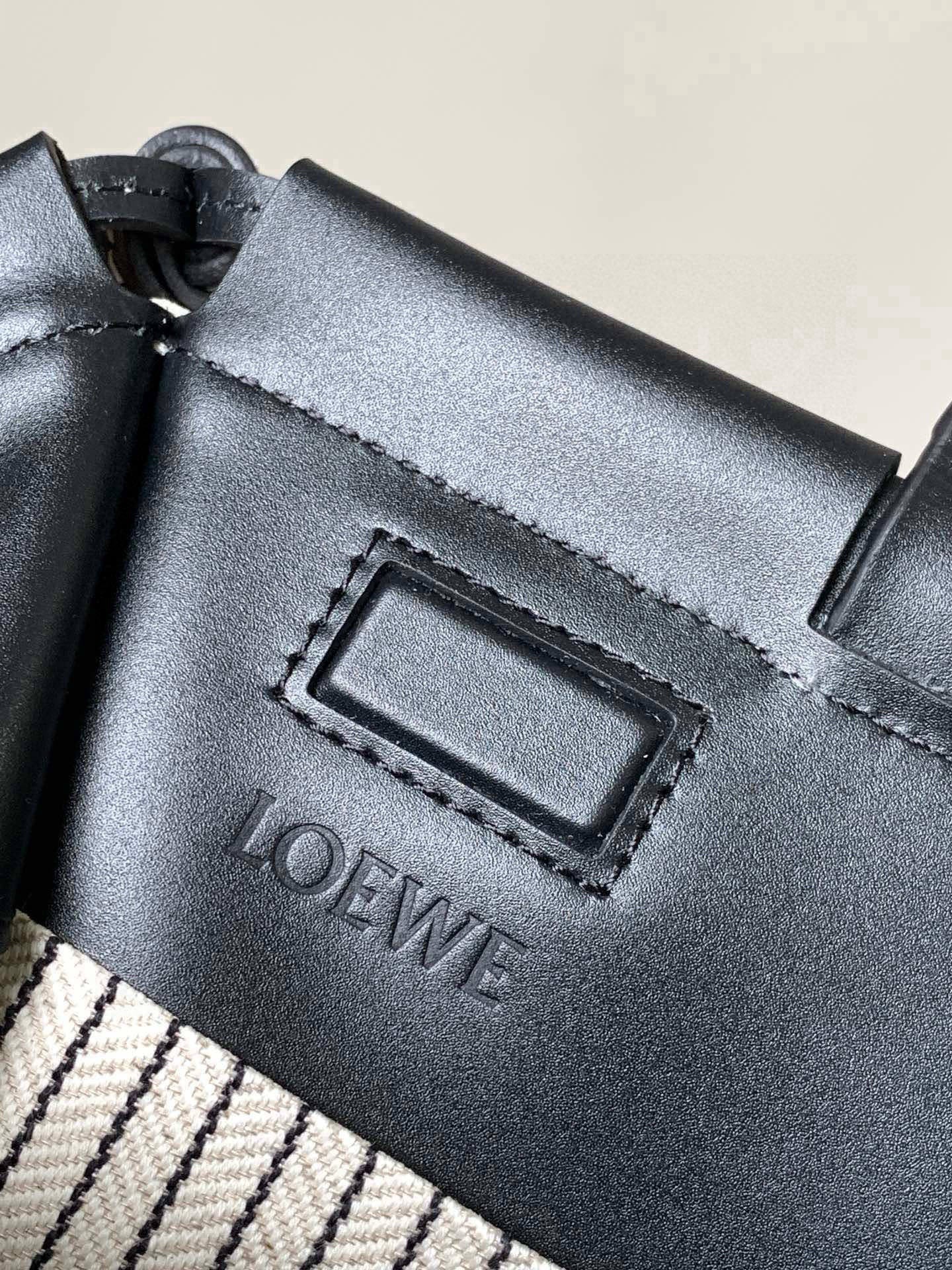 Black leather detail close-up with rectangular stitching and embossed LOEWE logo
