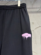 Dark pants with pink mountain graphic print on the leg