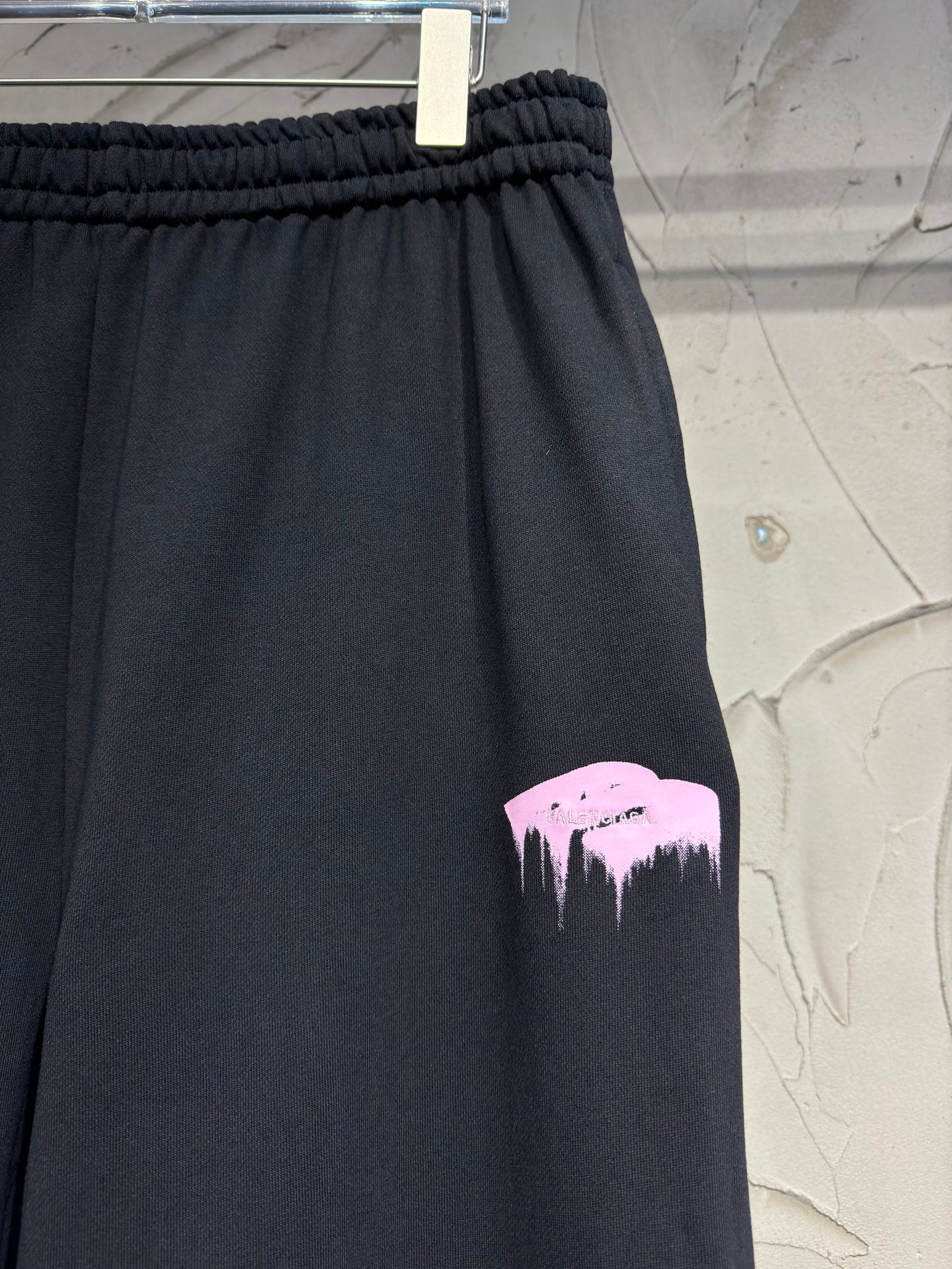 Dark pants with pink mountain graphic print on the leg
