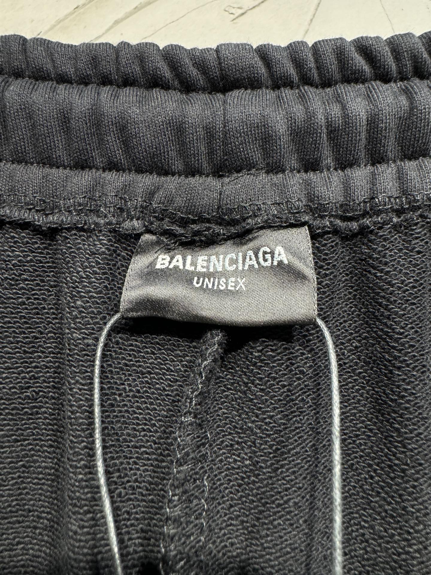 Black pants with BALENCIAGA UNISEX label at elastic waistband