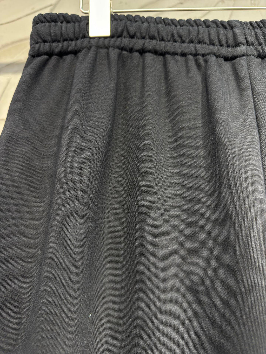 Dark pants with gathered elastic waistband and textured knit fabric